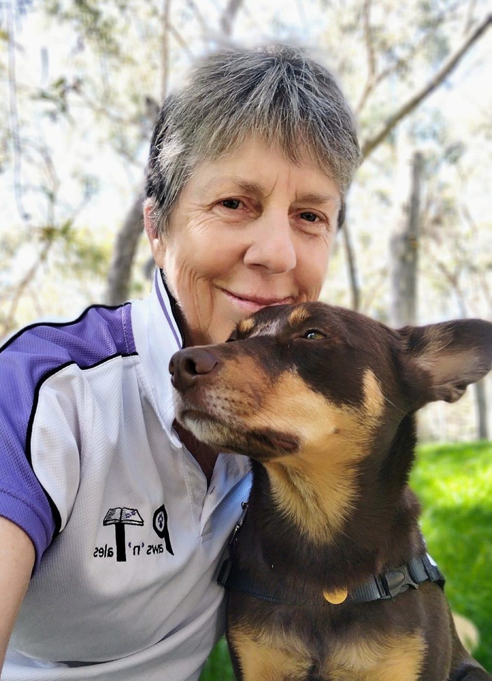 A volunteer cheek to cheek with her kelpie