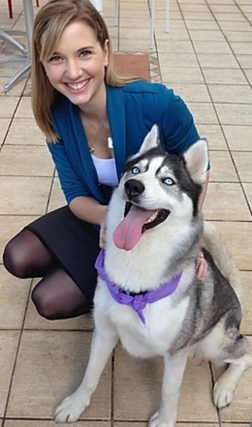 A volunteer kneeling with her husky