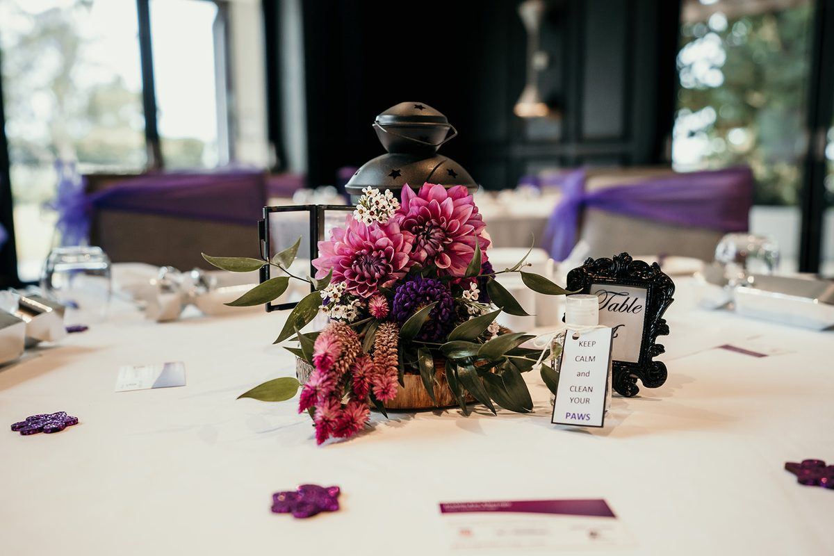 A purple and white table centrepiece at a PAWS event