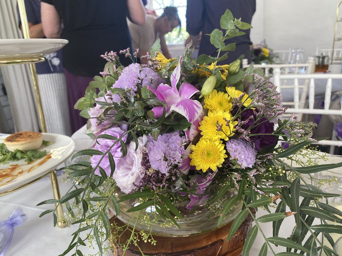 Purple and yellow flowers on a PAWS lunch table