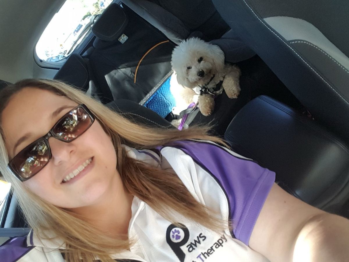 A volunteer taking a selfie with her golden retriever PAWS therapy dog