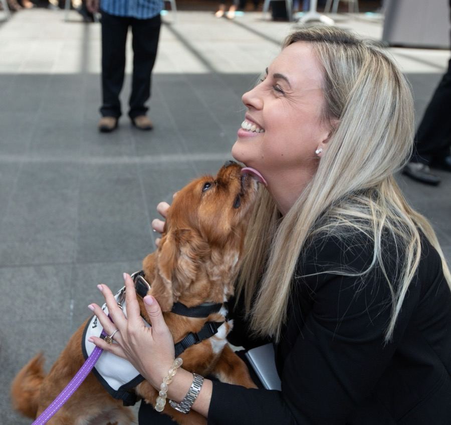 A joyful PAWS therapy dog giving its handler a lick on the cheek