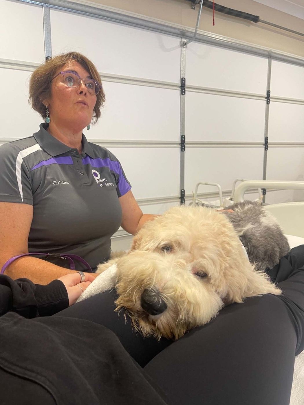 A resident hugging a PAWS therapy dog on a hospital visit