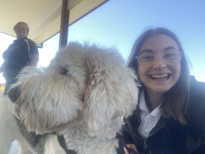 A girl cuddling a fluffy PAWS dog