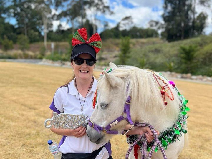 A handler with her pony in a paddock