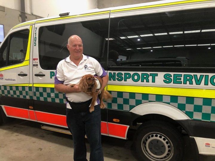 A volunteer and his dog beside an ambulance