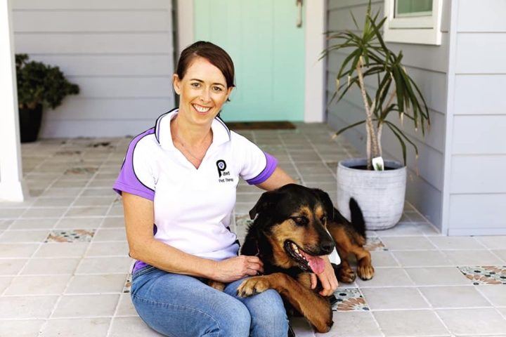 A volunteer smiling with her dog