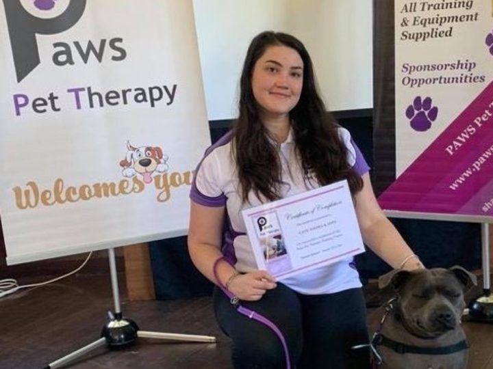 A volunteer with her certificate and dog