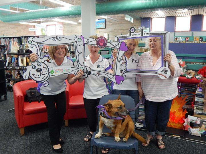 PAWS volunteers with their dogs in a library