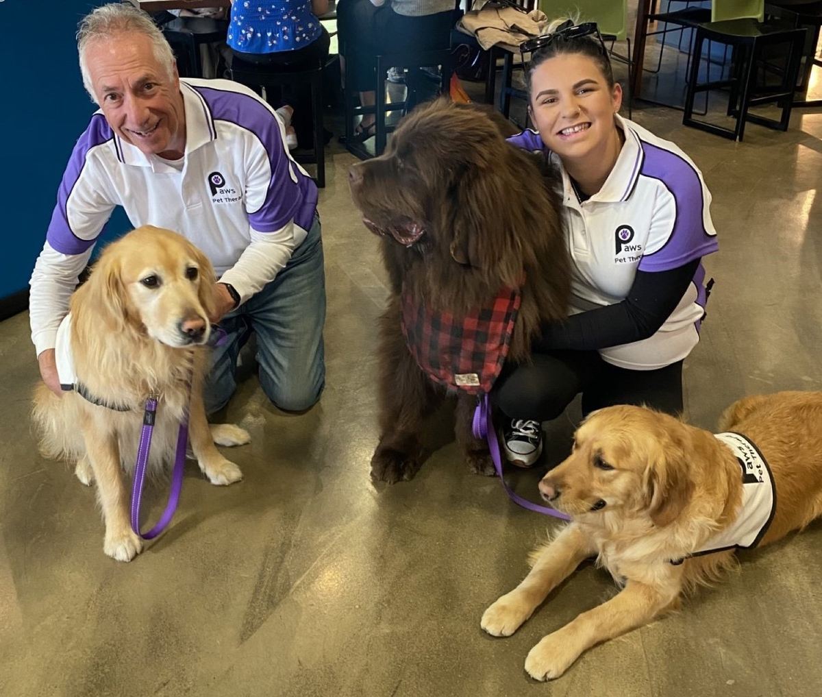 Two PAWS volunteers with their two therapy dogs