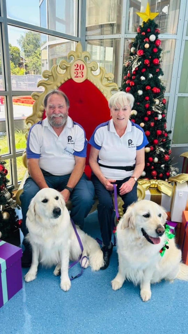 Volunteers and their white dogs at a Christmas visit